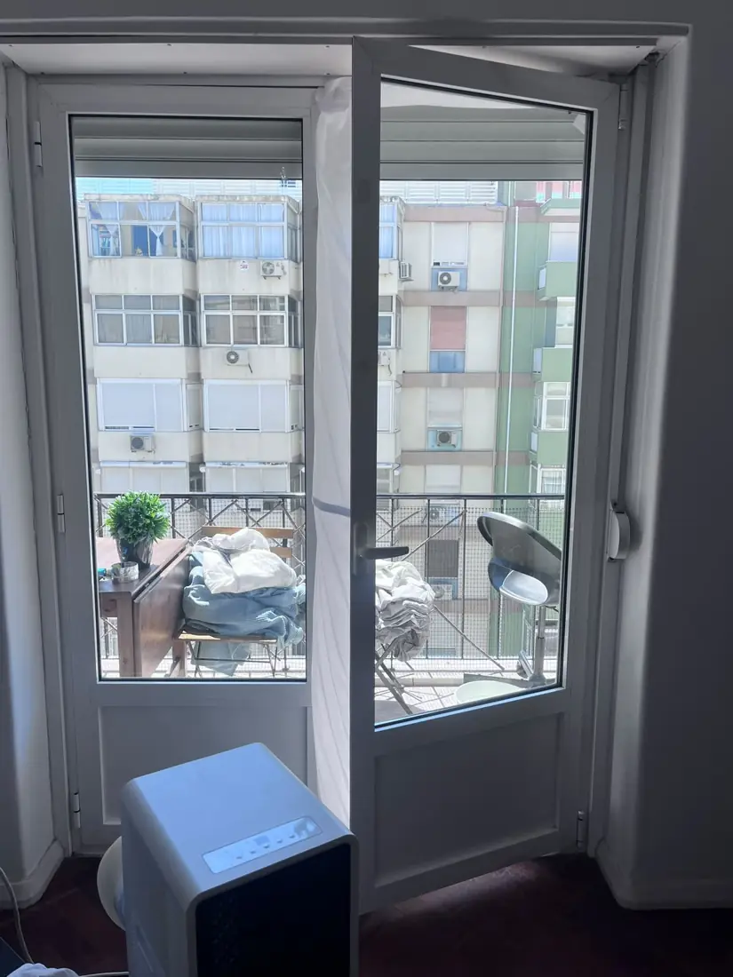 Ar condicionado portátil de aluguer junto a uma porta de varanda num apartamento em Belém