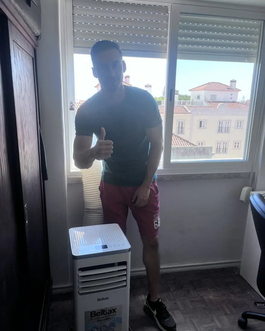Cliente da AC Rental Lisbon ao lado do ar condicionado portátil alugado em Lisboa