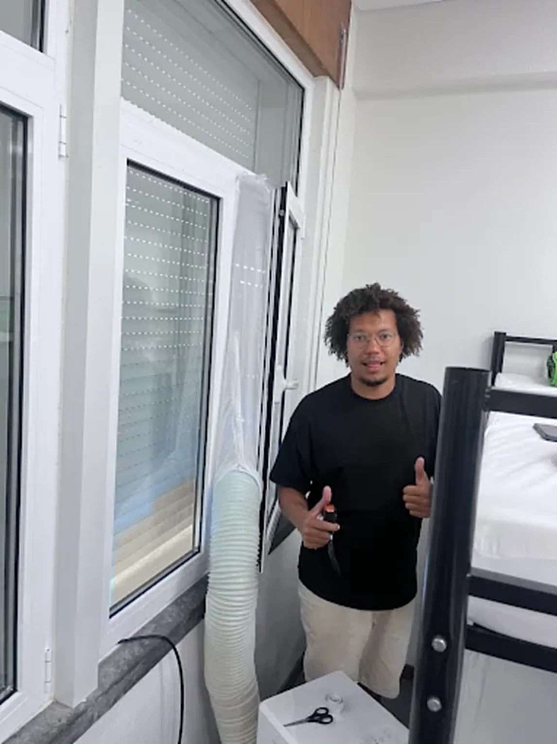 Ar condicionado portátil de aluguer pronto a usar, com mangueira pela janela, num apartamento em Lisboa